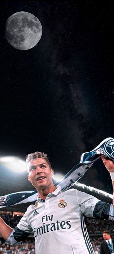 a man holding a tennis racquet in front of a full moon