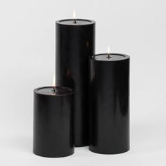 three black candles sitting next to each other