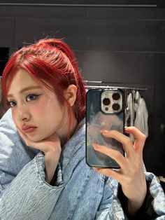 a woman with red hair is taking a selfie in front of her phone case