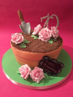 a birthday cake with pink flowers and a knife in the center on a green plate