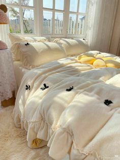 a bed with white sheets and yellow pillows