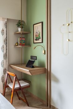 a laptop computer sitting on top of a wooden desk next to a shelf filled with books