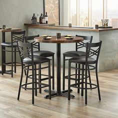 a table with four stools in front of it and a bar area behind it