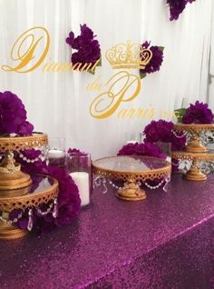 the table is covered with purple flowers and candles