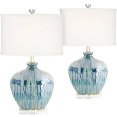 two blue and white vases with lamps on them