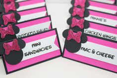 pink and black place cards with minnie mouse ears on them for guests to eat at