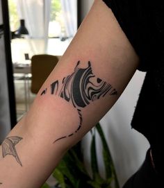 a person with a tattoo on their arm that has a fish in the middle of it