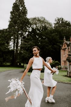 two women in white dresses walking down the street