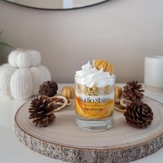 a glass jar filled with food sitting on top of a wooden table next to pine cones