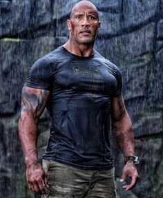 the rock standing in the rain with his hands on his hips