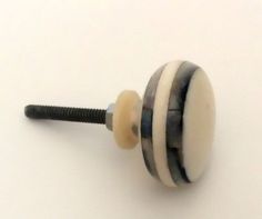 a white and black knob on a white surface