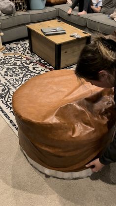 people sitting on couches in a living room with one person covering the other's face