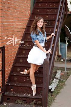 a young woman posing on the steps of a building