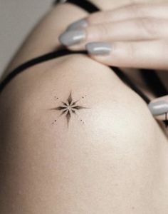 a woman's arm with a small star tattoo on her left side ribcage