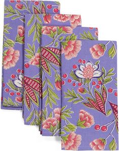 four purple napkins with pink flowers and green leaves on them, all folded up