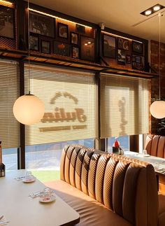 an empty restaurant with tables and chairs in front of large windows that have blinds on them