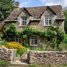 an old stone house with ivy growing on it