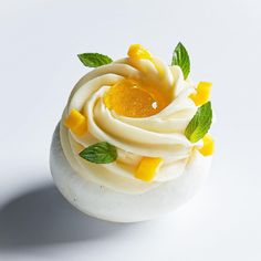 a cupcake with white frosting and green leaves on top