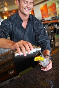 a man is making a drink at the bar