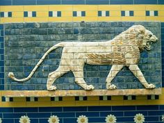 a lion painted on the side of a wall in an egyptian style pattern with blue and yellow tiles