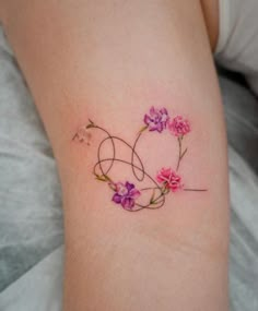 a woman's arm with flowers on it and the word love written in cursive writing