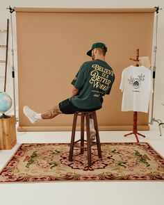 a man sitting on top of a wooden stool