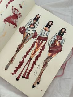 an open book with drawings of women in clothes