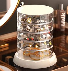 a display case filled with lots of jewelry on top of a table next to a mirror