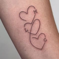 a small tattoo on the leg of a woman's thigh with two hearts attached to it