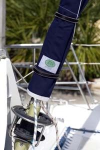 the back end of a sailboat with an umbrella on it's side and palm trees in the background