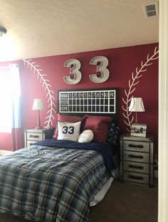 a bedroom decorated in red, white and blue with baseball themed decor on the wall