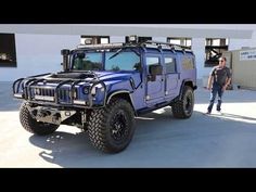 a man standing next to a blue hummer truck