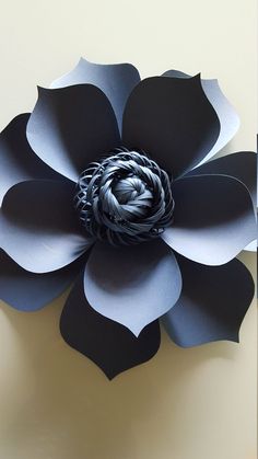 a black and white paper flower sitting on top of a wall