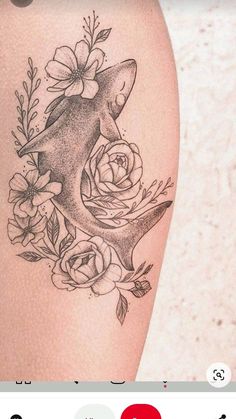 an image of a tattoo with flowers on the thigh and a shark in the middle