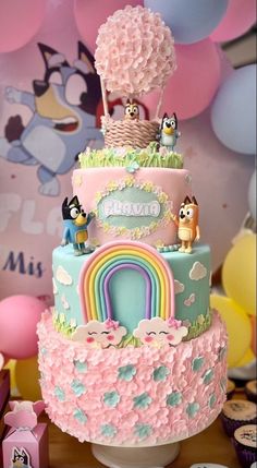 there is a multi layer cake decorated with animals and rainbows on the top tier