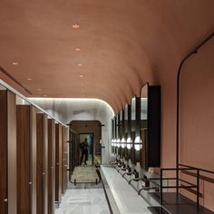 the hallway is lined with brown and white walls, along with several lights on either side