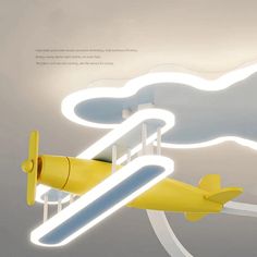 a yellow airplane is flying in the sky with clouds above it and below it are lights