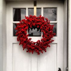 a red wreath is hanging on the front door