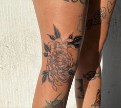 two women with tattoos on their legs and one has a flower tattoo on her leg