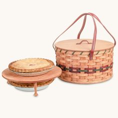 a wooden basket with a pie on it and a plate next to it that is sitting in front of the basket