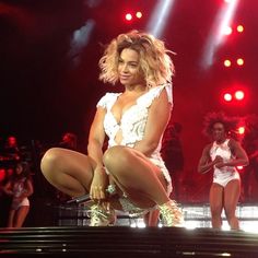 the woman is performing on stage with her legs spread out