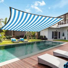 an outdoor swimming pool with blue and white striped awning