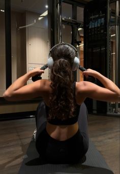 a woman sitting on the floor listening to music with headphones in front of her