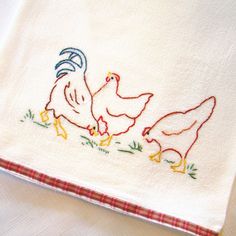 two chickens on a white towel with red trim