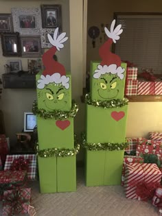 two green boxes stacked on top of each other in front of christmas presents and gifts