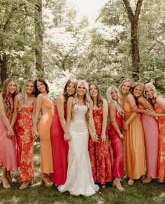 a group of women standing next to each other in dresses