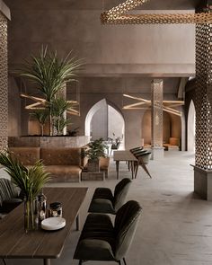 the interior of a modern restaurant with wooden tables, chairs and potted palm trees