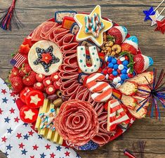 an american flag made out of food on top of a wooden table with red, white and blue decorations