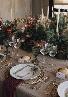 a table set for christmas dinner with place settings