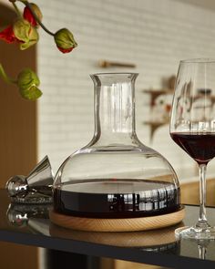 a wine decanter sitting on top of a table next to a glass of wine